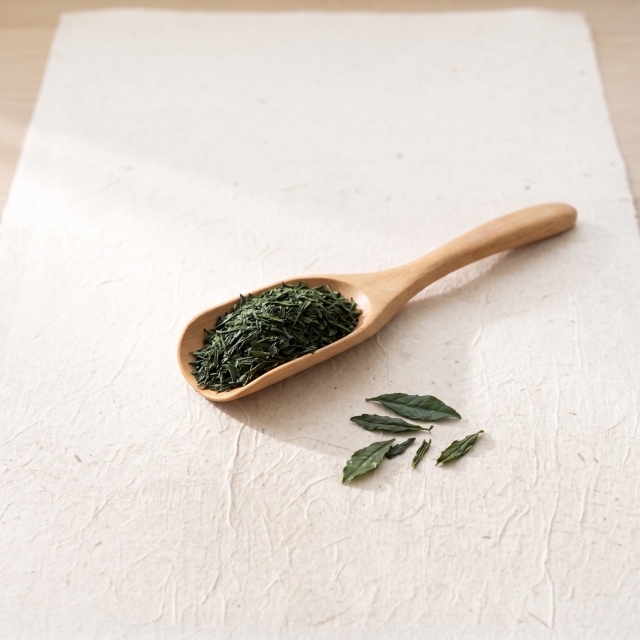 木の茶さじにのせた深蒸し茶の茶葉
